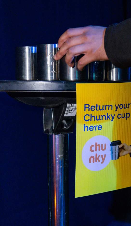 A table at an event filled with reusable chunky coffee cups
