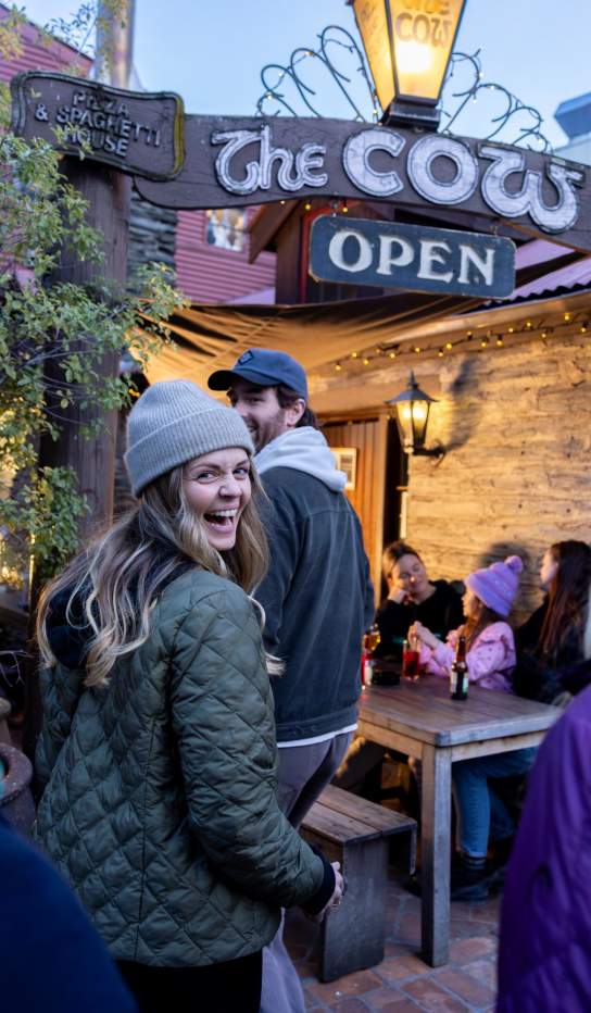 Group of friends walking into a restaurant called The Cow