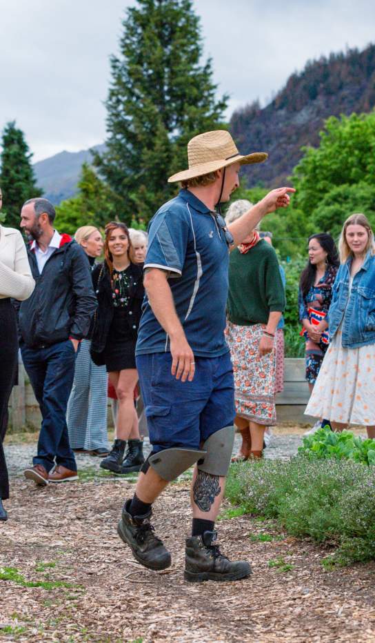 A group of people on a tour through a big vegetable garden