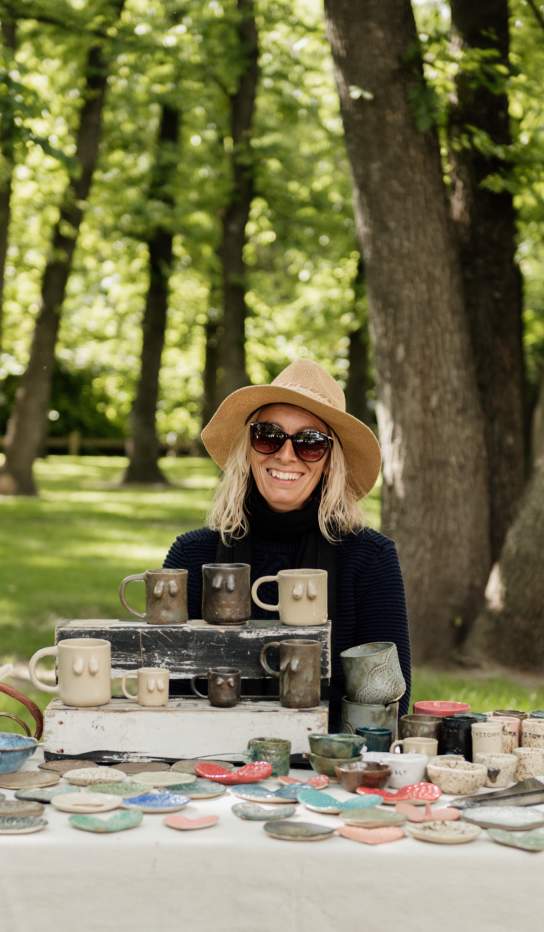 Smiling stallholder with clay crafts at Arrowtown Market