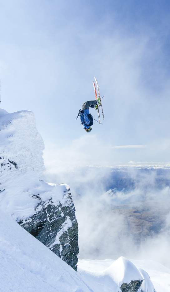 Person doing backflip over rocks at Treble Cone