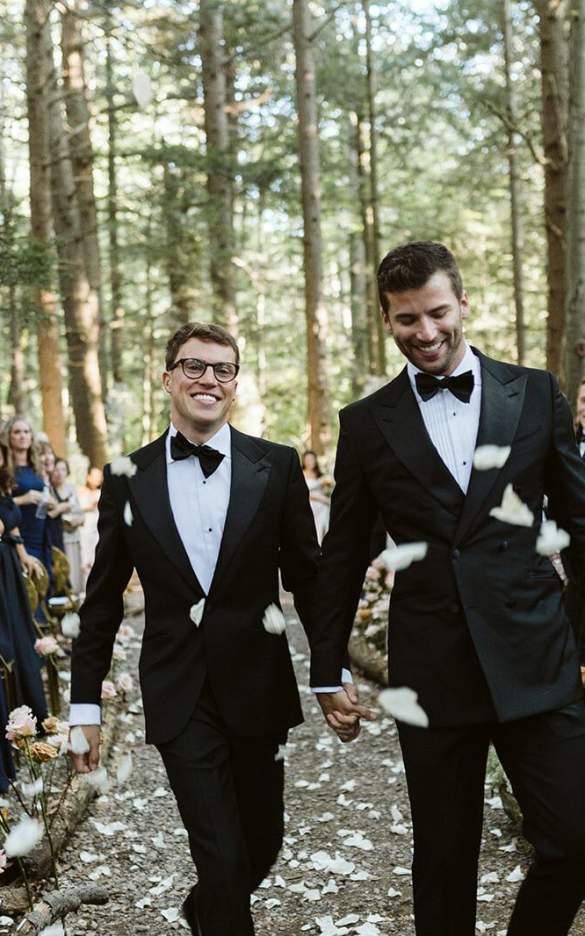 Two grooms walking down the isle hand in hand