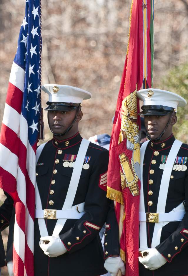 Marines in uniform holding flags for a ceremony