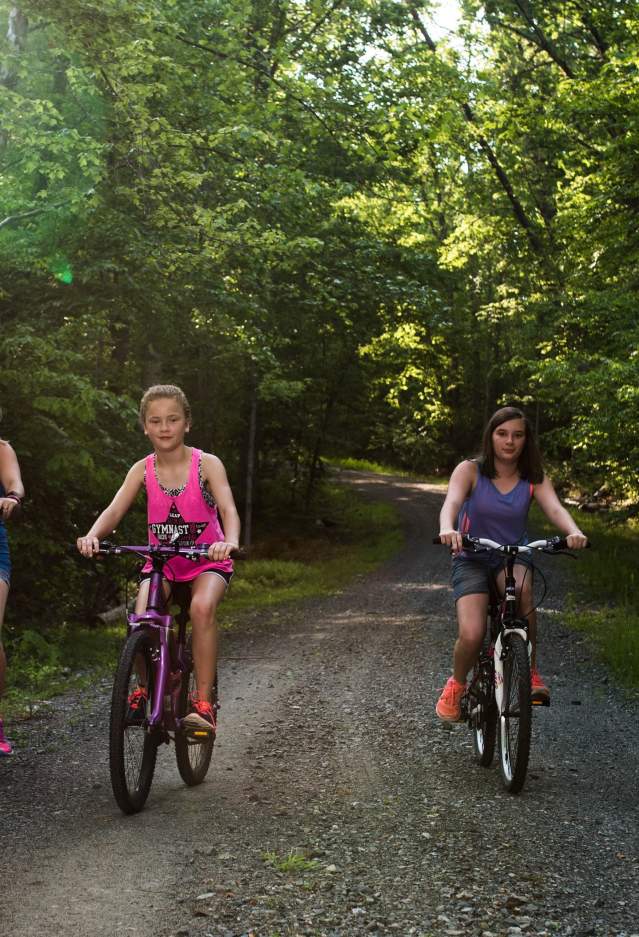 family biking on a path in the forest
