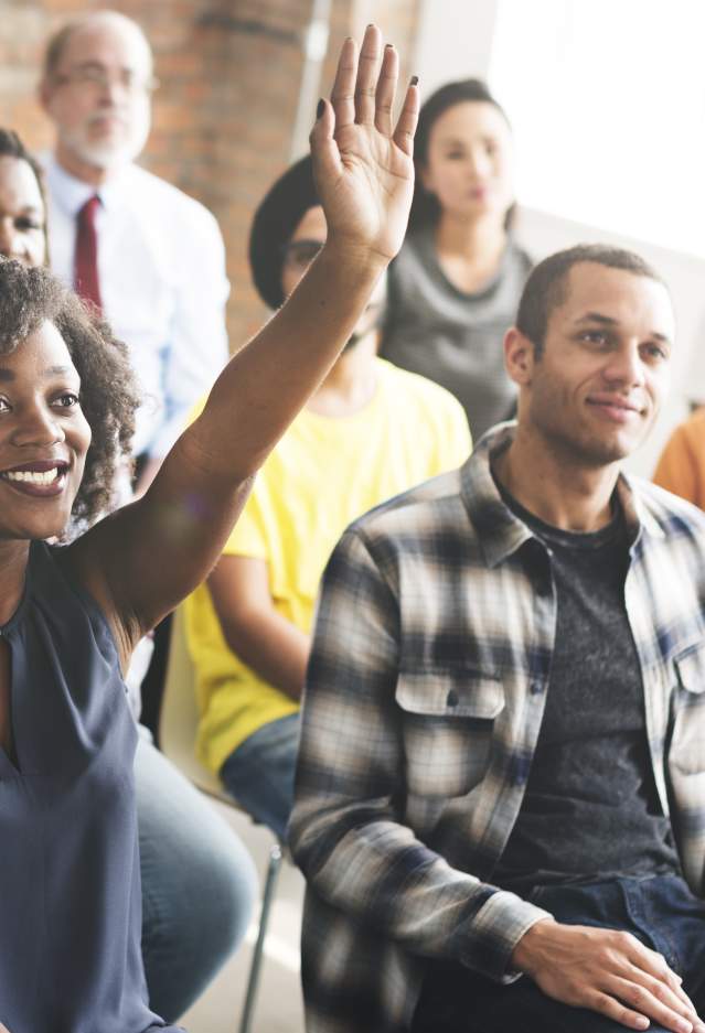 Woman raising hand in group meeting