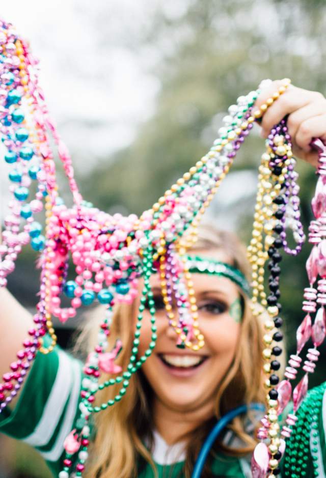 Woman holding beads during St. Patrick's day parade