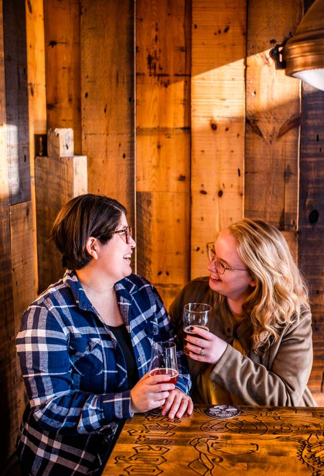 Two people toasting glasses at a Wauwatosa bar