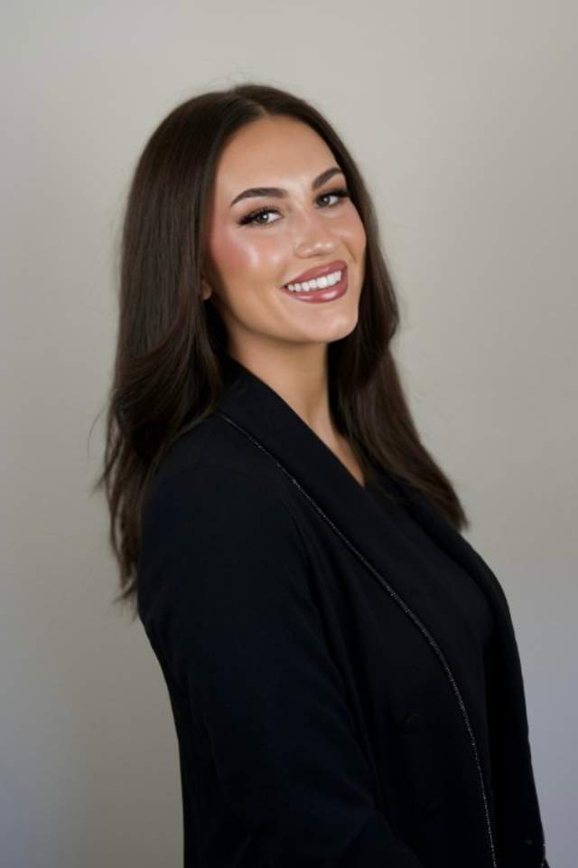 Abi Hammonds smiling, wearing a black blazer