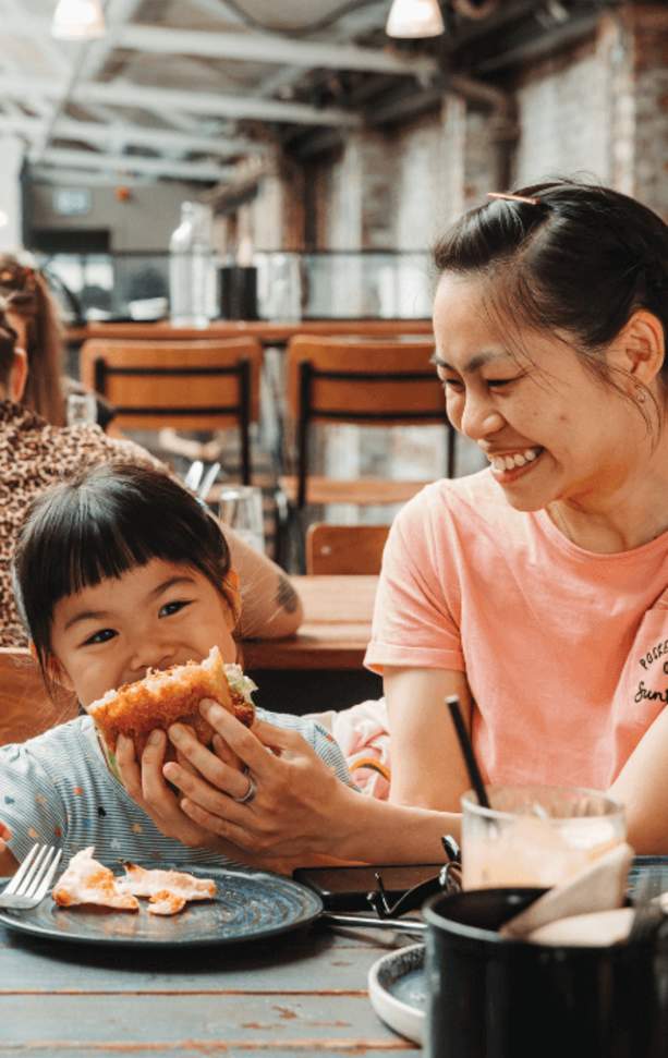 A young child biting into a sandwich