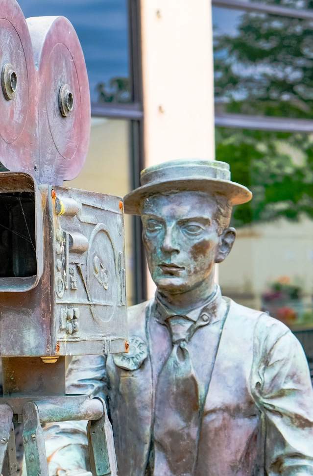 bronze statue of silent film star buster keaton with movie camera