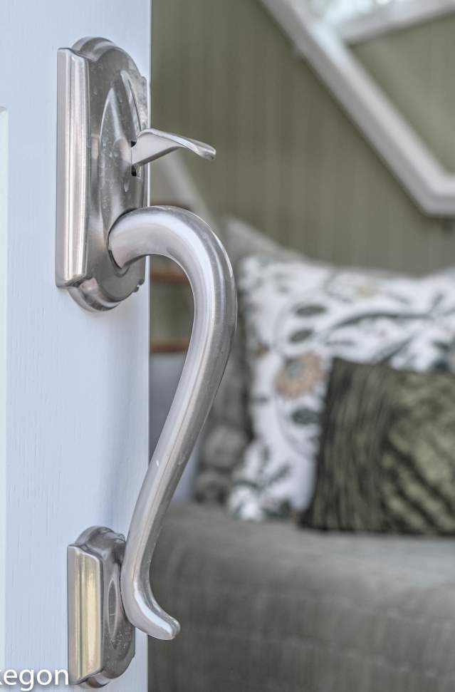 view of door handle on open door with vacation rental living area in background