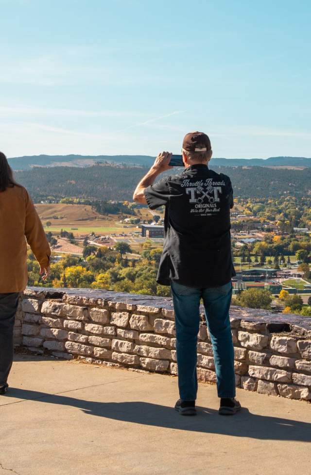 two people at Stonewall Overlook on Skyline Drive looking over rapid city, sd