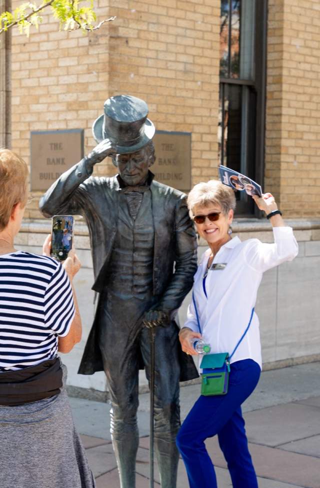 group posing with james monroe city of president statue in rapid city, sd