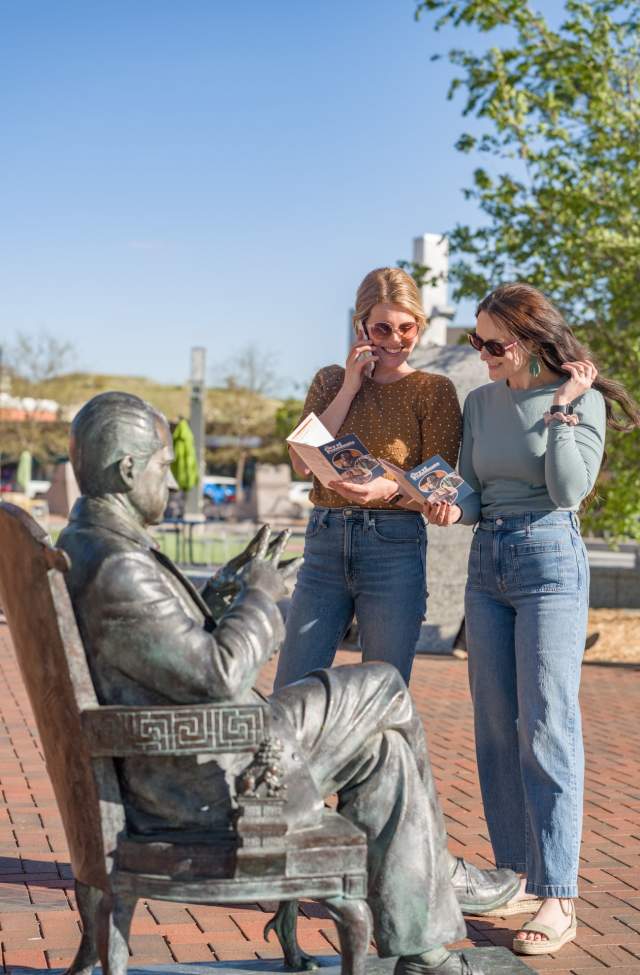 two visitors listening to the audio tour of the city of presidents in downtown rapid city