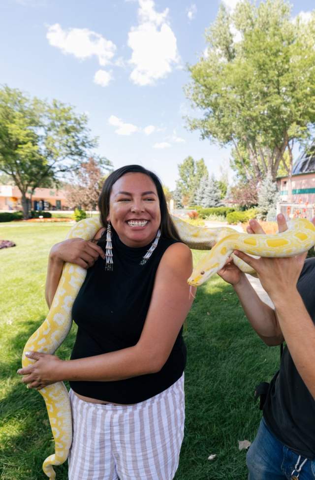 women holding python at reptile gardens with handler in rapid city, sd