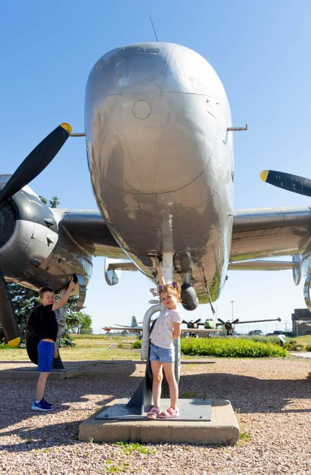 kids posing with an airplane on display at the south dakota air and space museum