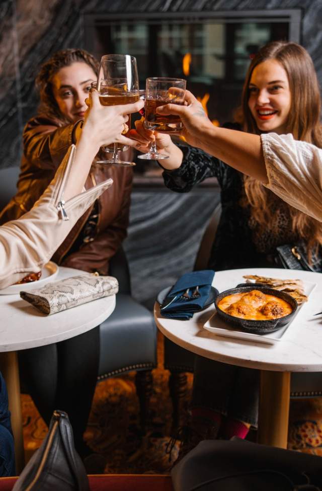 Women seated at tables, toasting