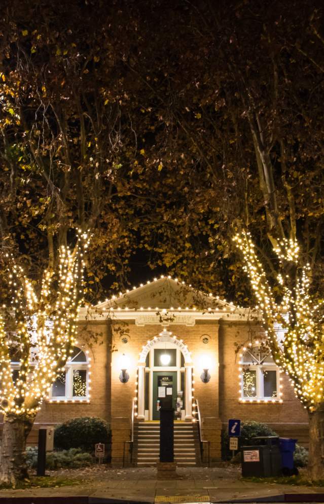 Visitor Center building form the outside during the holidays decorated with white lights.