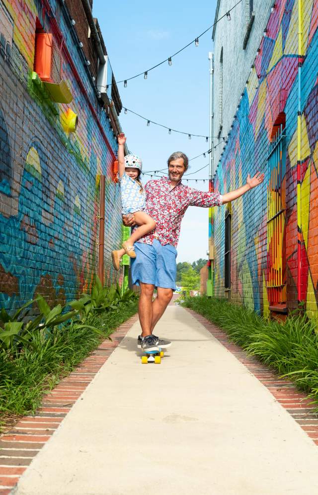 Dad and daughter skateboarding by "Alley on State" mural in West Columbia (Vagabond3 visit).