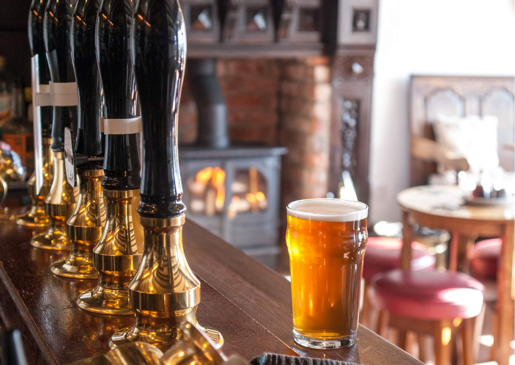 A pint of beer on a bar in a cosy pub