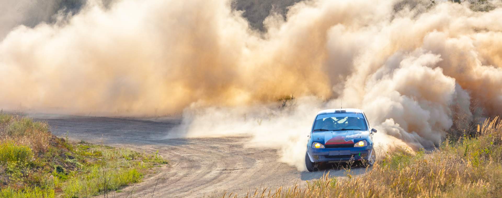 A car racing on a dirt road in East Yorkshire leaving huge plumes of dust behind it