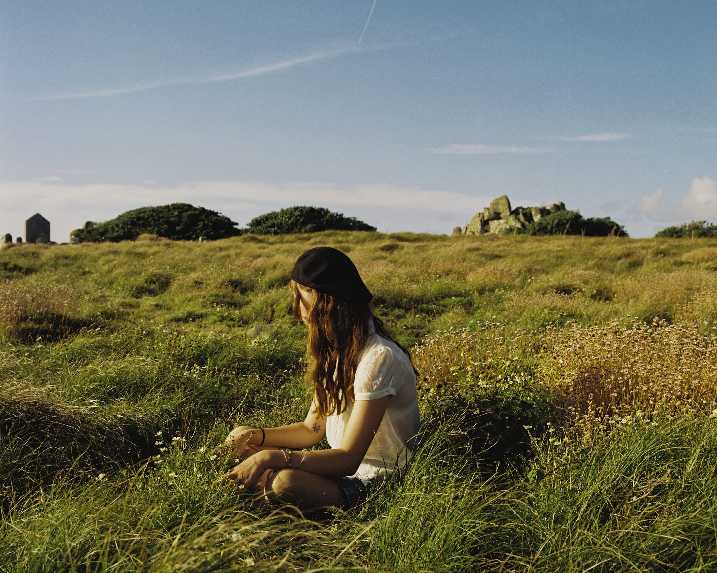 Girl sitting on grass in Autumn