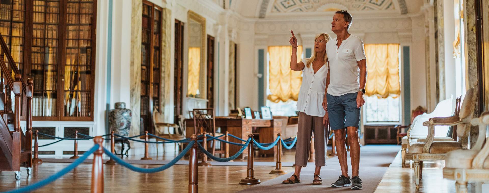 A couple exploring one of the grand rooms at Sledmere House in East Yorkshire