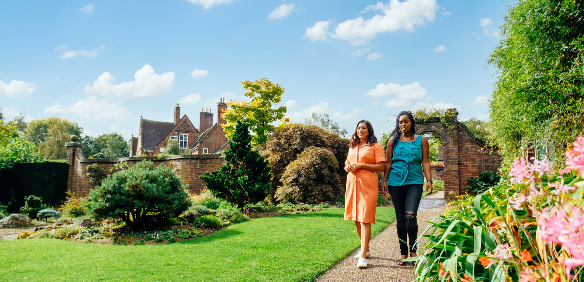 Two people walking down a path outside of Exploring Winterbourne House and Garden in Birmingham