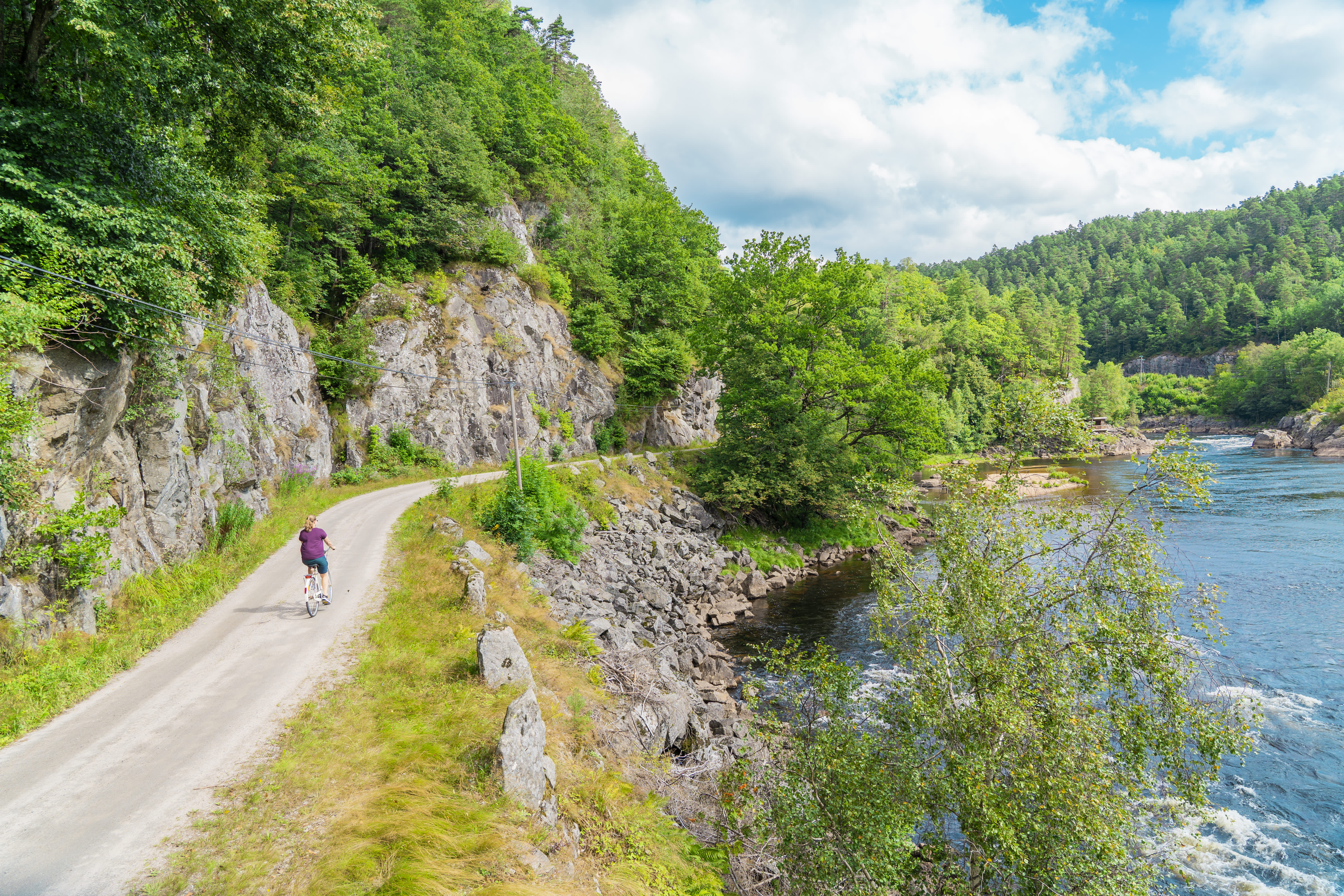 Woman biking along the river