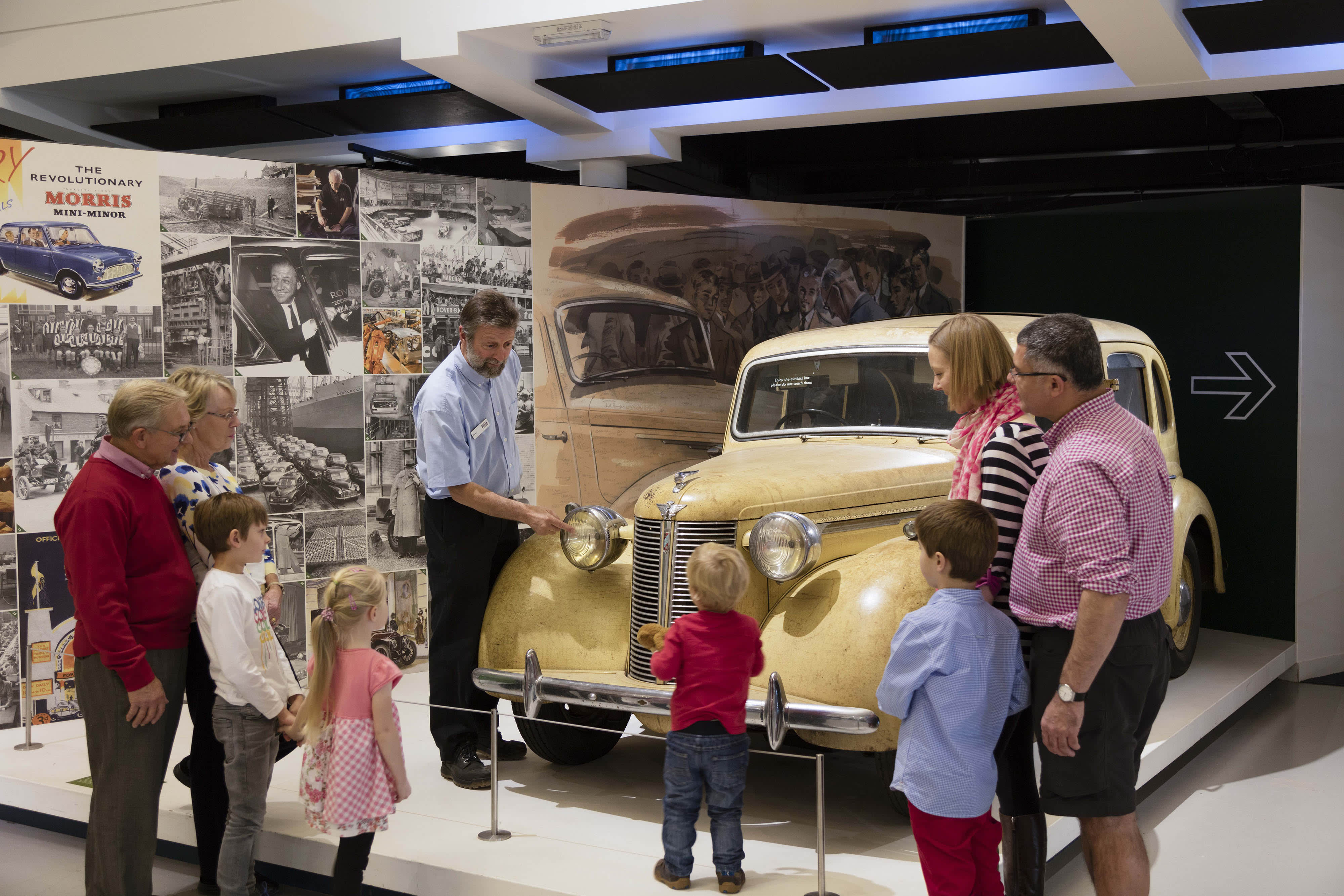 Children and parents looking at a car at the British Motor Museum