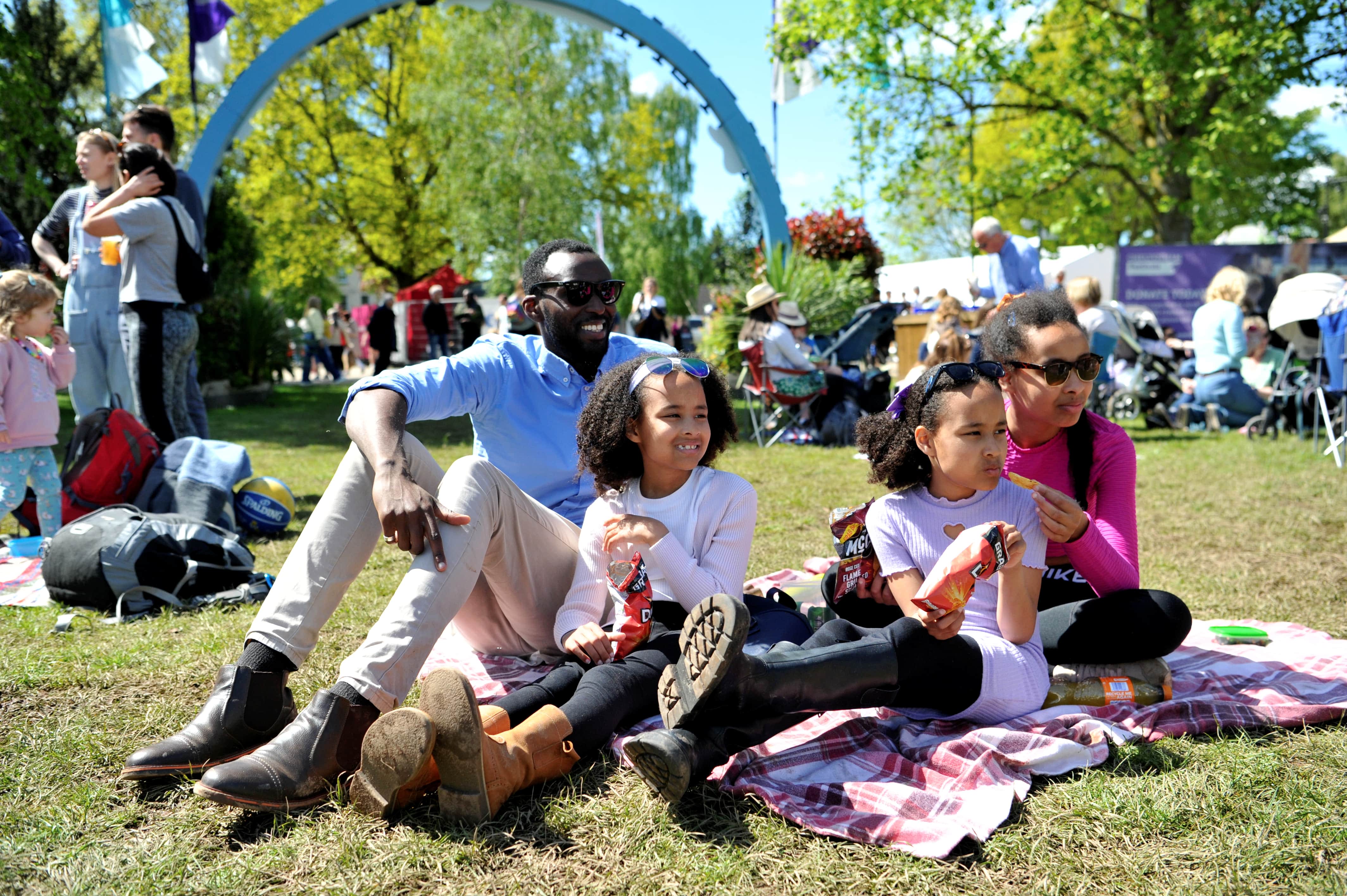Family sitting in the grass at the Cheltenham Jazz Festival, Imperial Gardens.