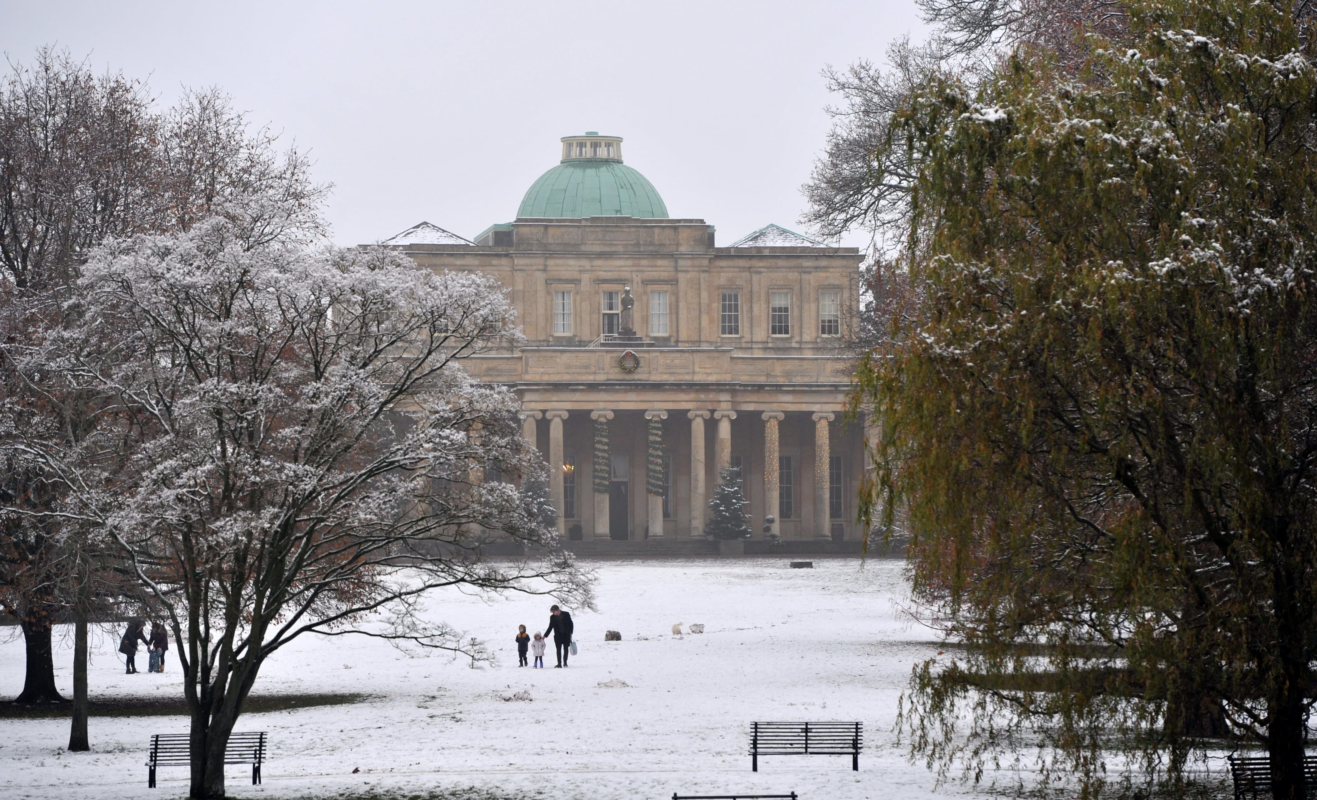 Visitors walking through a snow filled park in Cheltenham, Pittville Park in the snow
