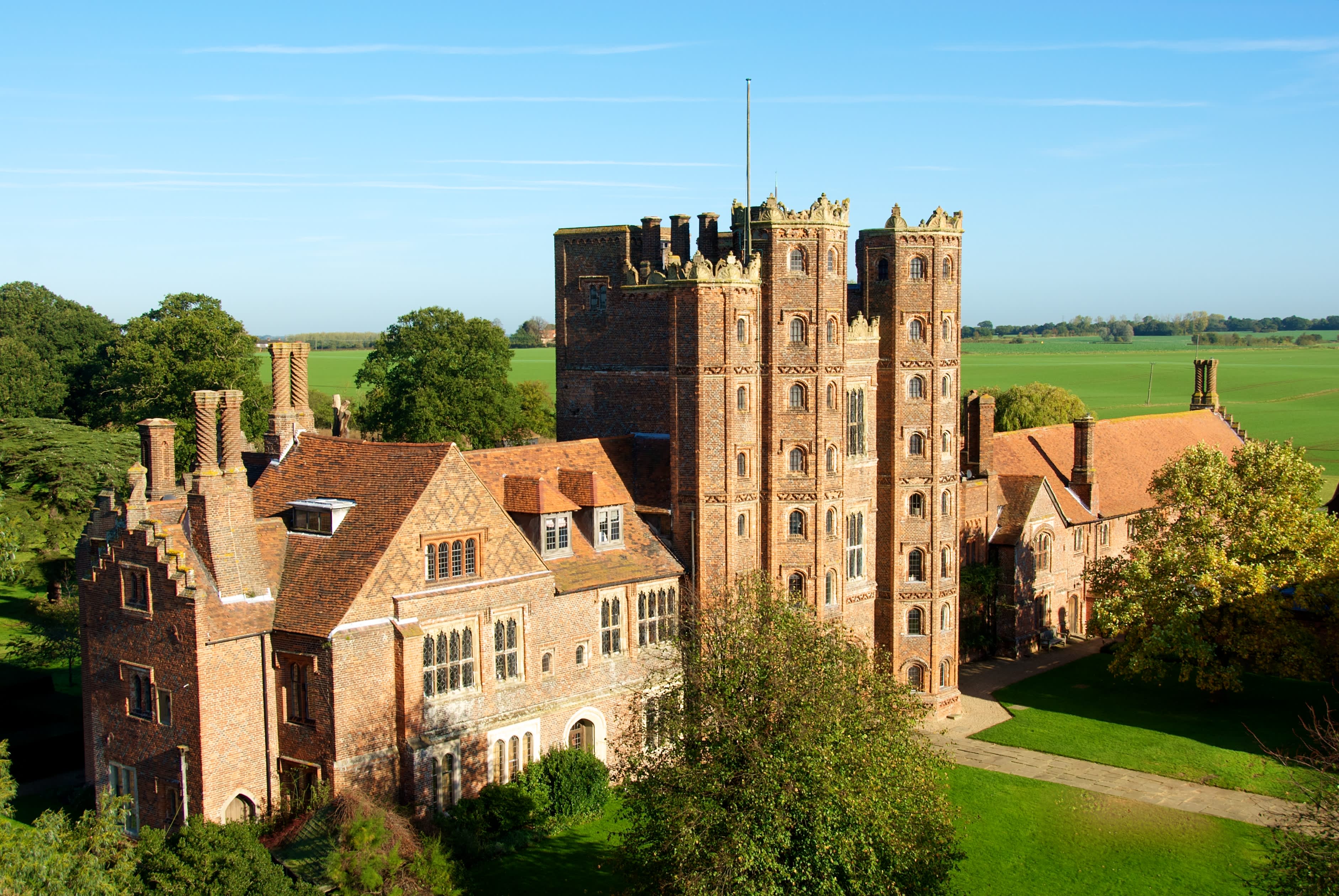 An impressive Tudor Tower, at least 8 stories high, nestles in verdant English countryside.