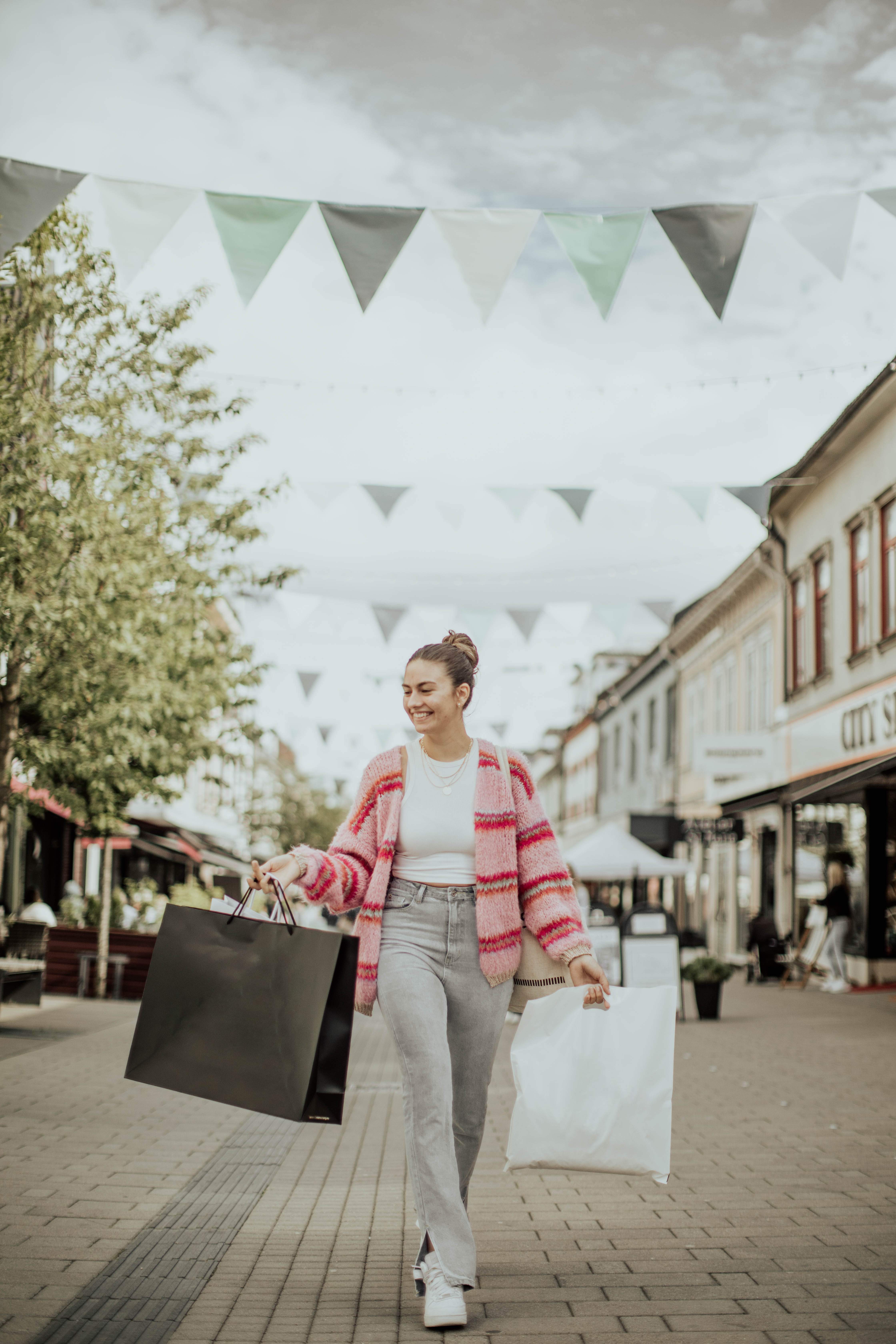 Kvinne på handleposer i hver hånd i gågata i Sarpsborg. Foto.