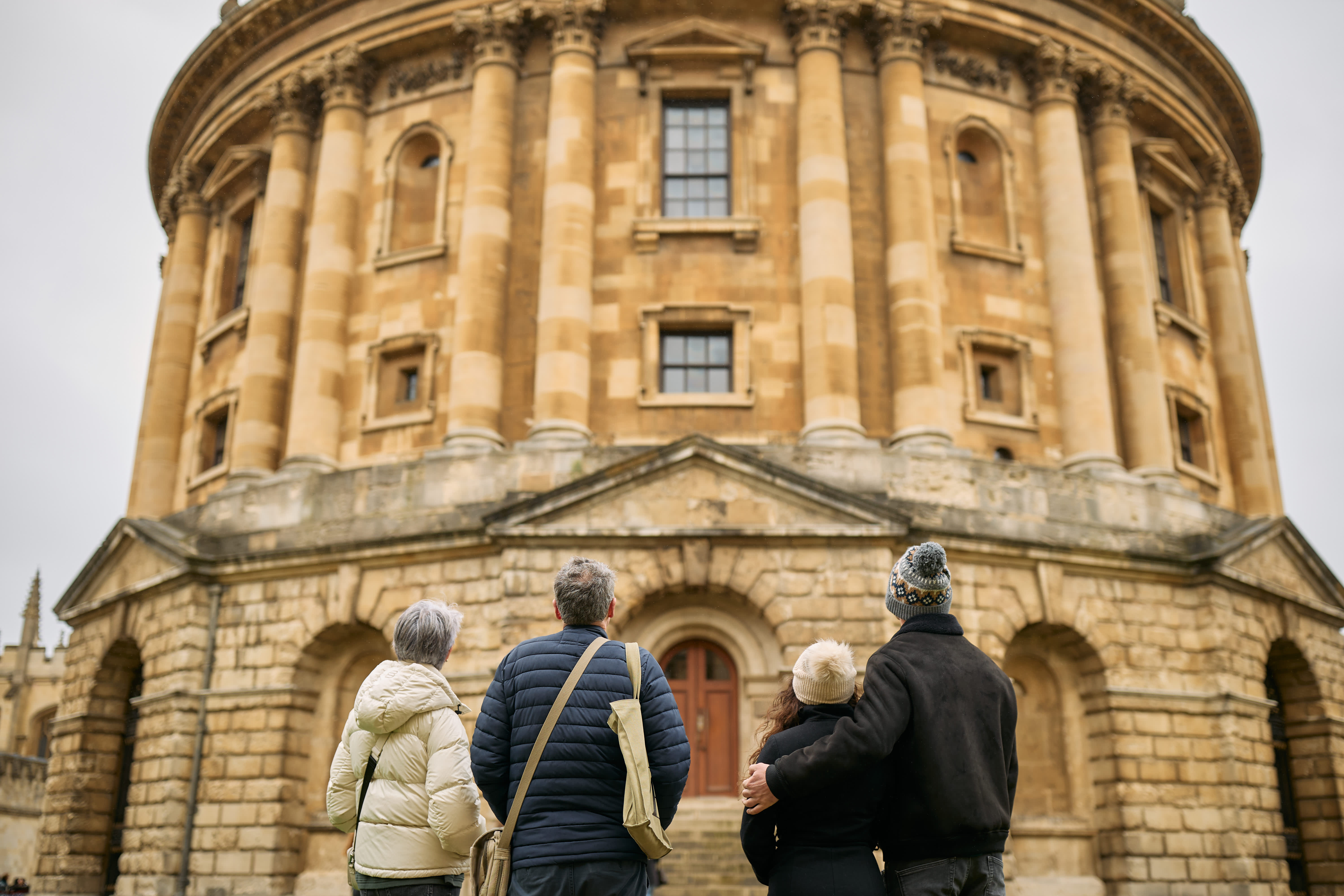 A group of people look at the outside of the historic Bodleian Library in Oxford