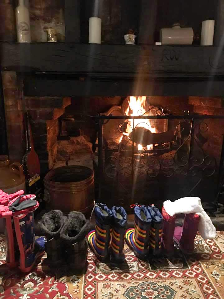 Line of wellie boots in front of fire at Waterloo Arms pub in Lyndhurst in the New Forest - Pub walks insp
