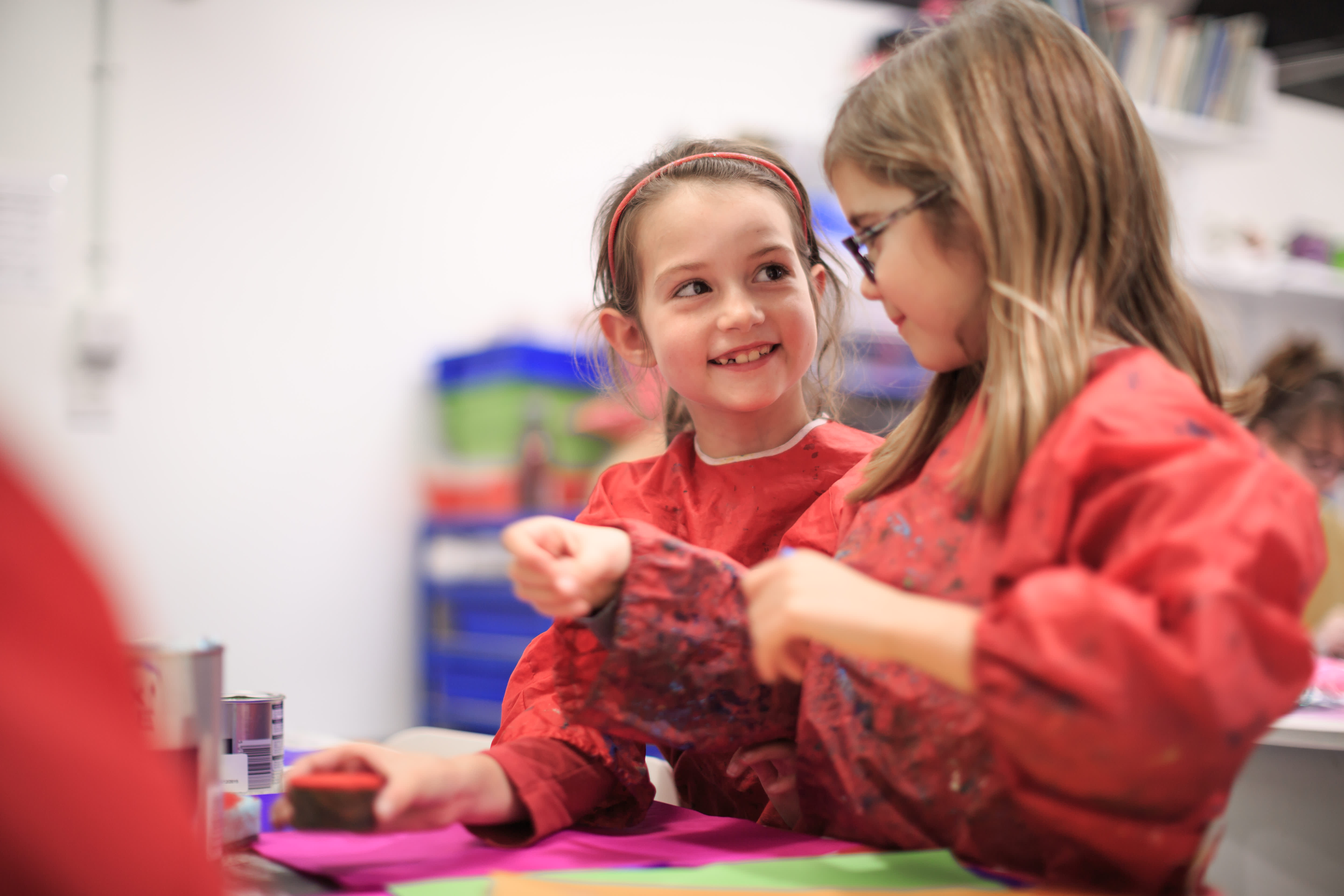 Children in aprons enjoying painting