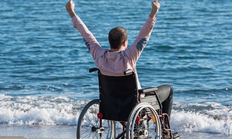 man in wheelchair on the beach