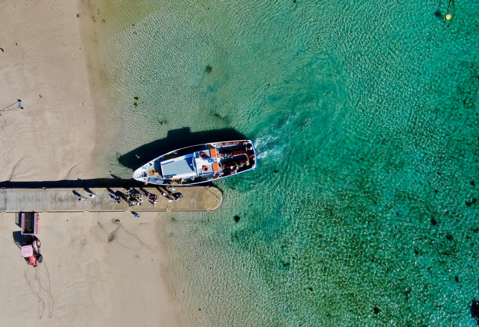 Aerial overlooking a tripper boat in turquoise waters