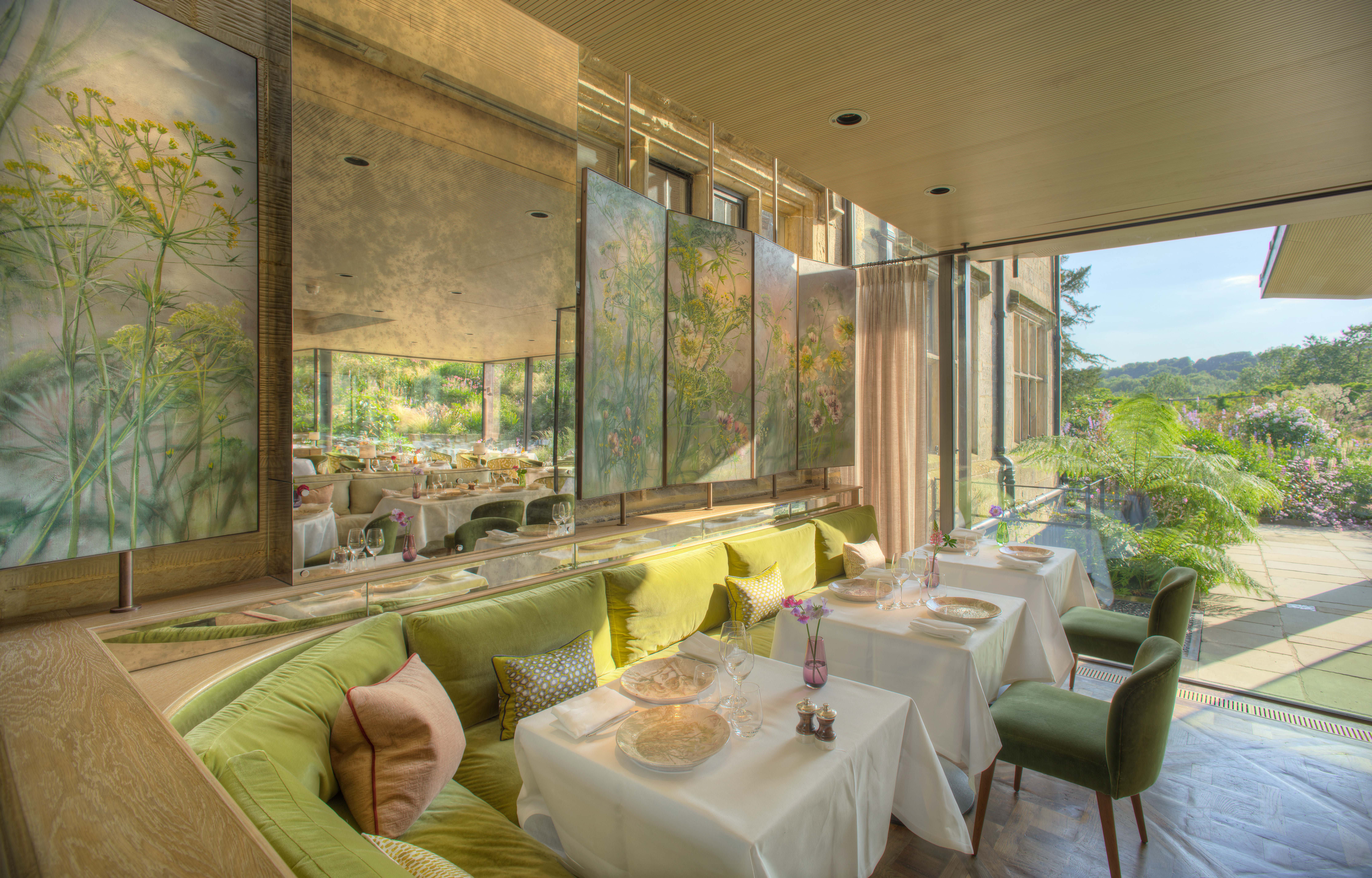 Interior tables at Gravetye Manor restaurant, with patio doors leading out to gardens