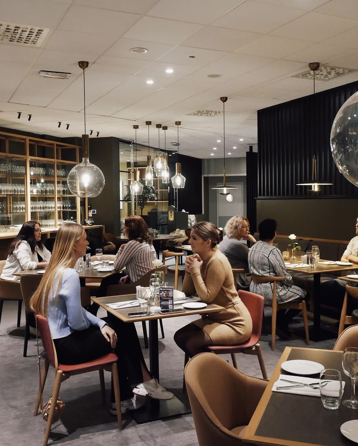 Mennesker som sitter i restauranten til Quality Hotel Sarpsborg. Foyo.