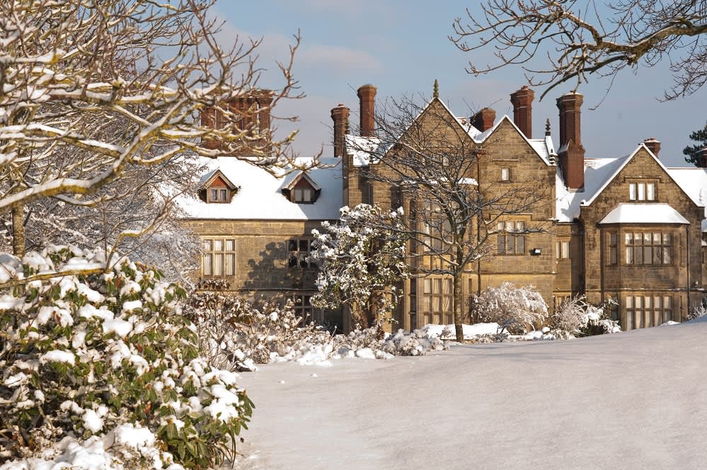 Snowy winter scene with a snow-topped stately home in Sussex