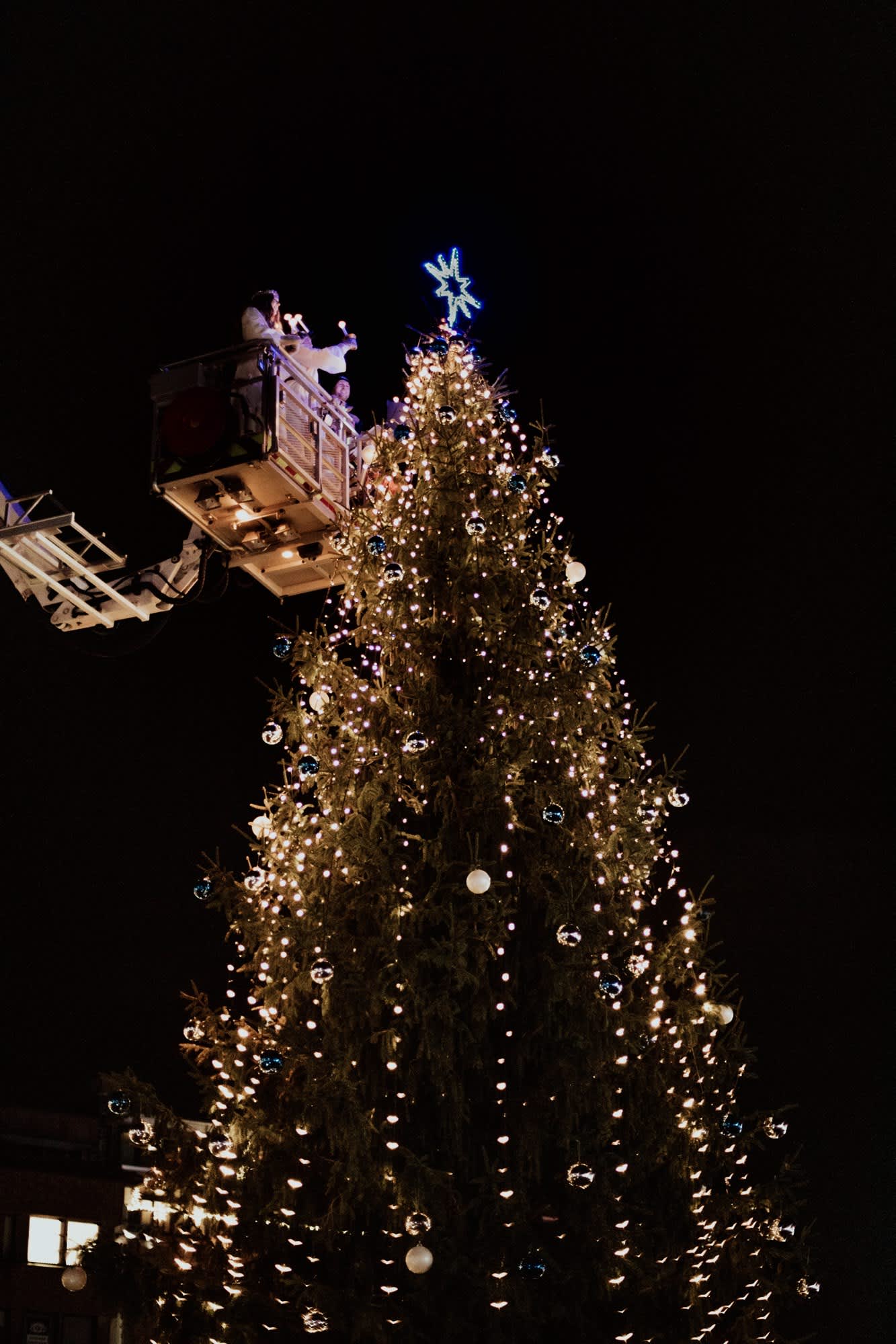 Lucia som tenner juletreet på torget i Sarpsborg fra en lift. Foto.