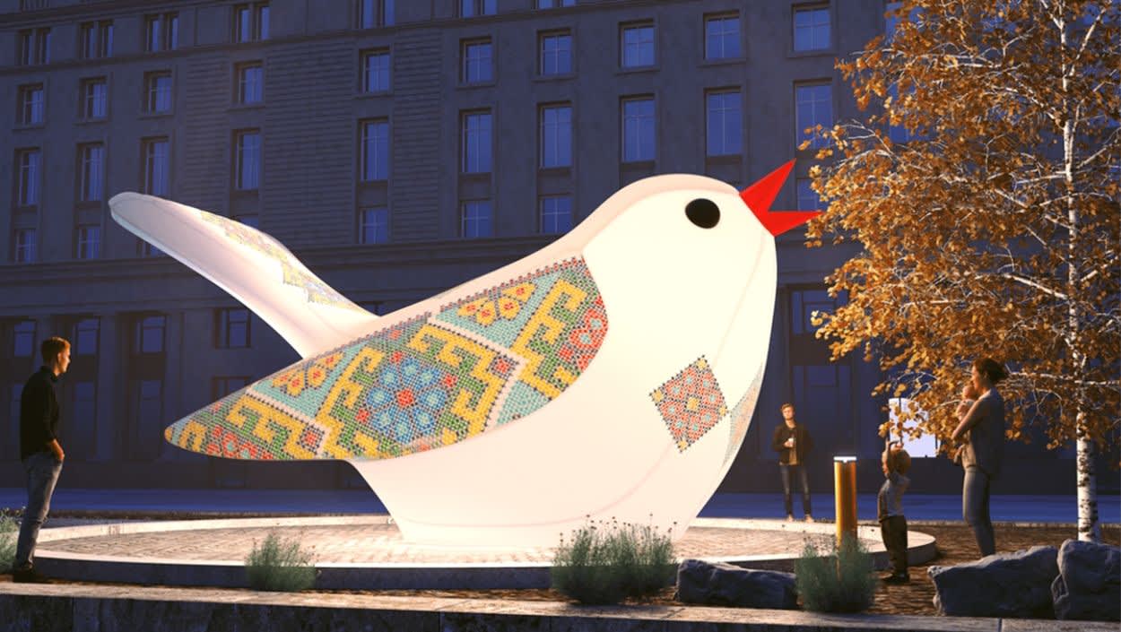 A large, illuminated bird sculpture on a water feature
