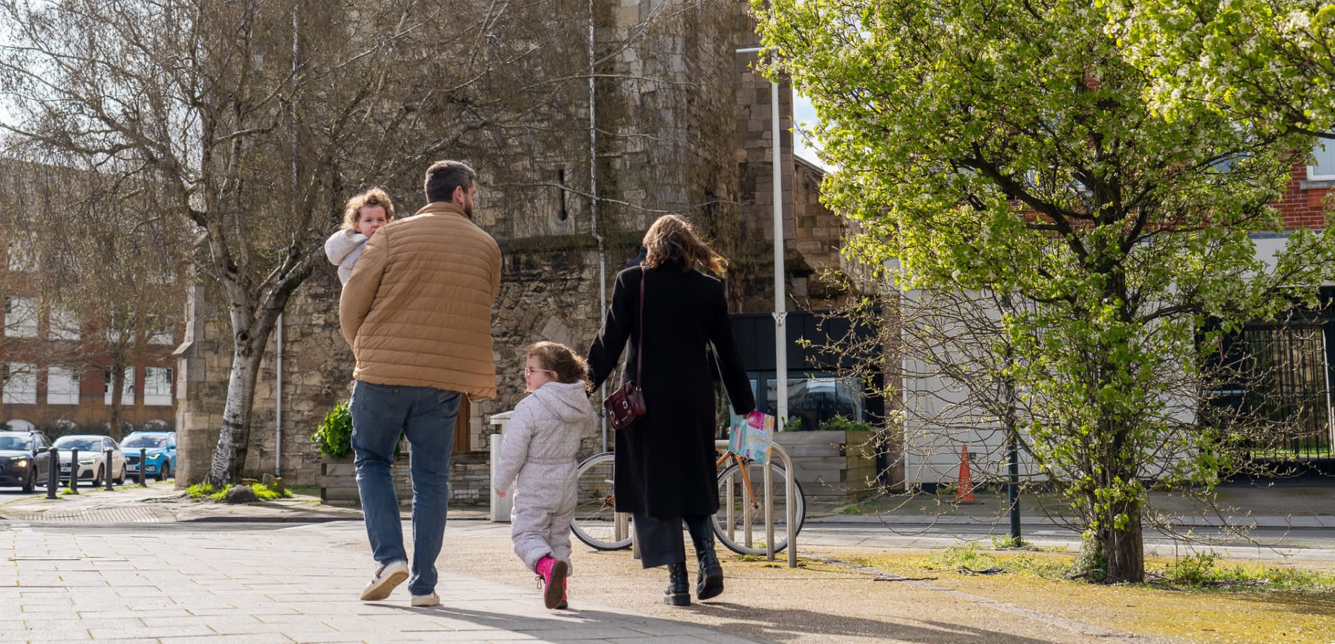 Young family walking on pavement with Easter trail maps in hand