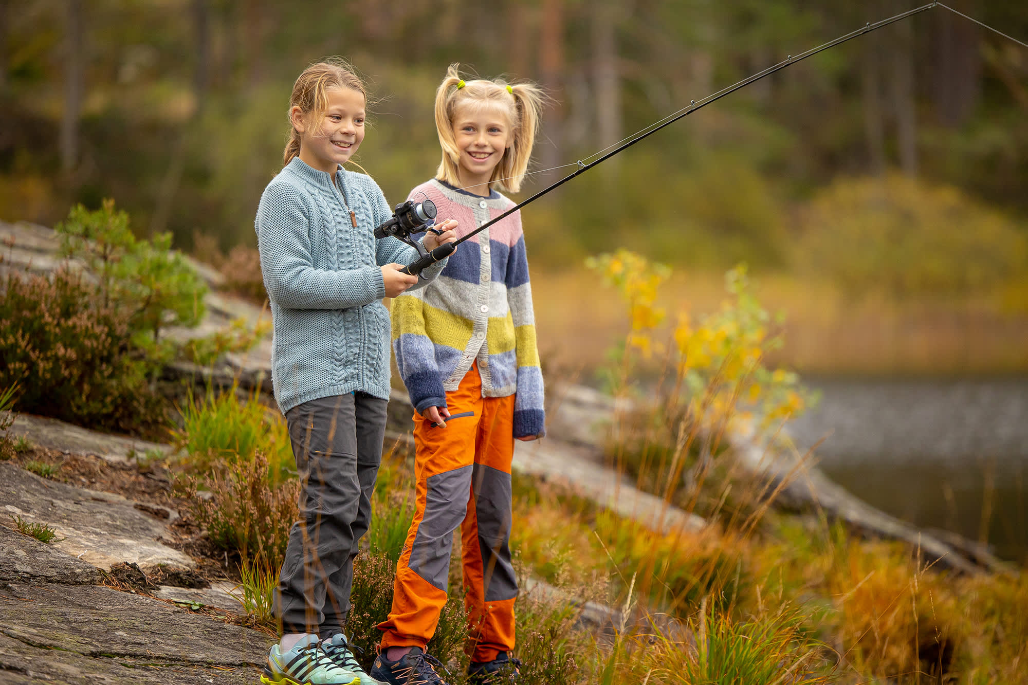 Two girls fishing by the lake