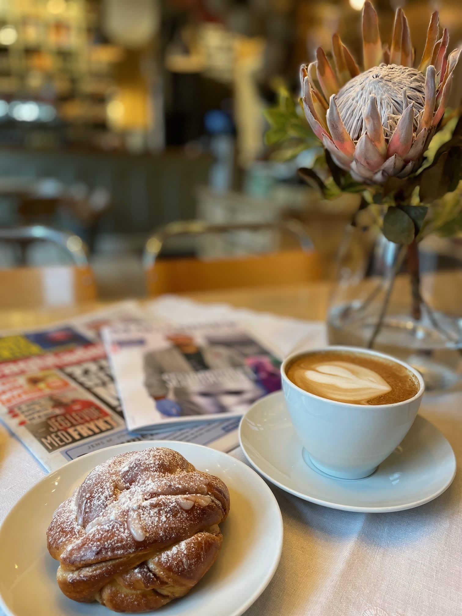En kaffekopp og en bolle på ett bord