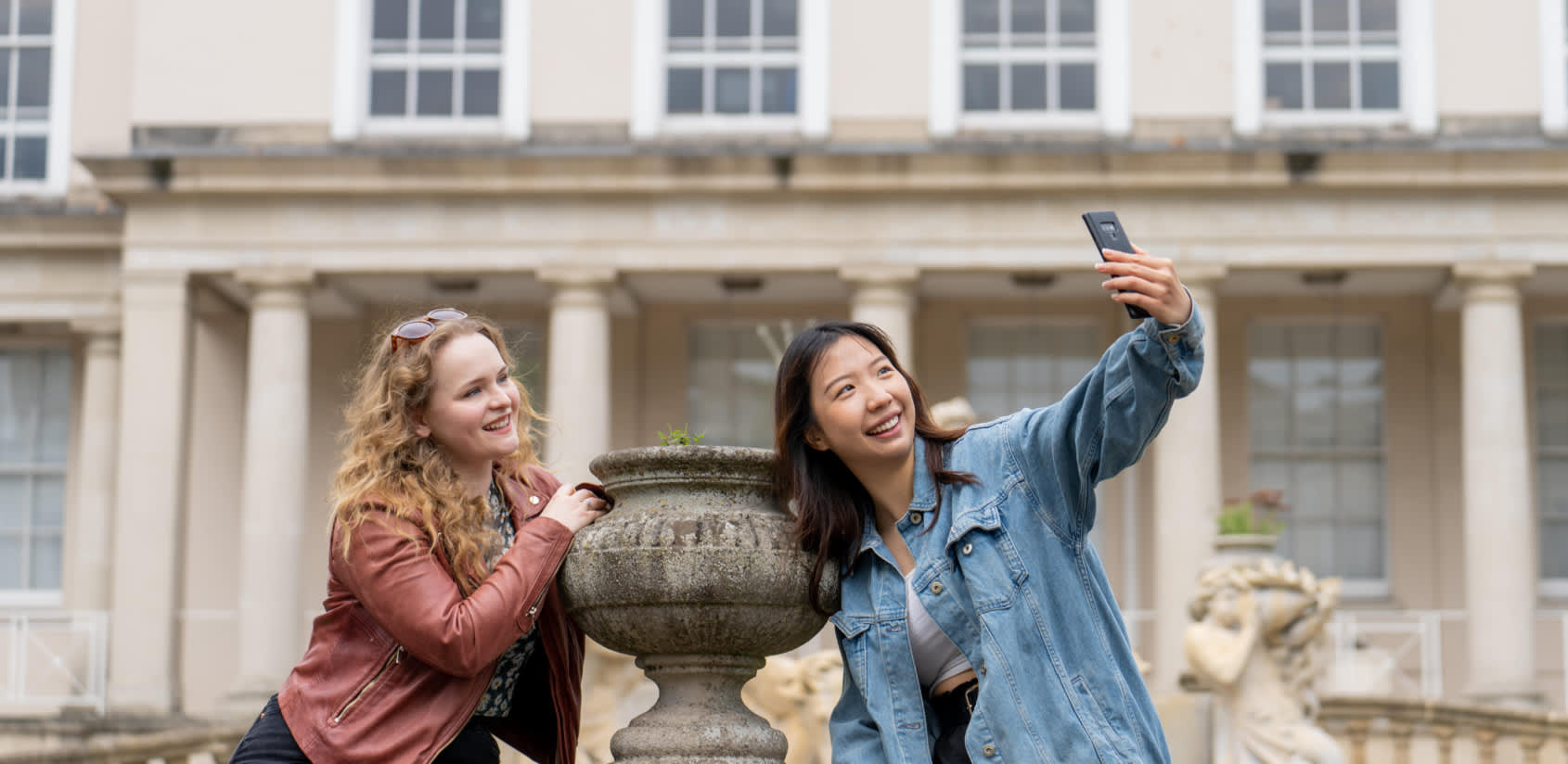 Visitors enjoying Cheltenham, taking a selfie near Neptune Fountain