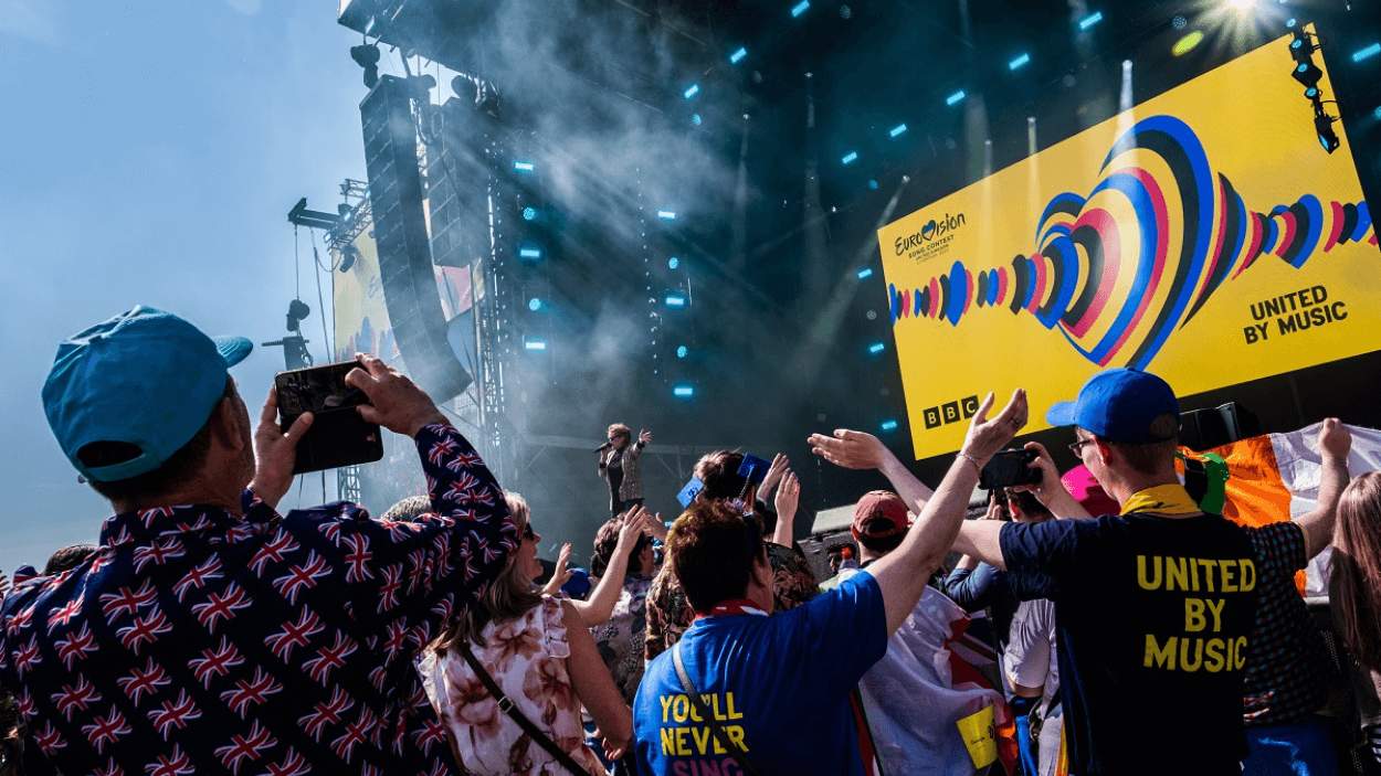 The stage at Eurovision Village in Liverpool with a crowd in front of it.
