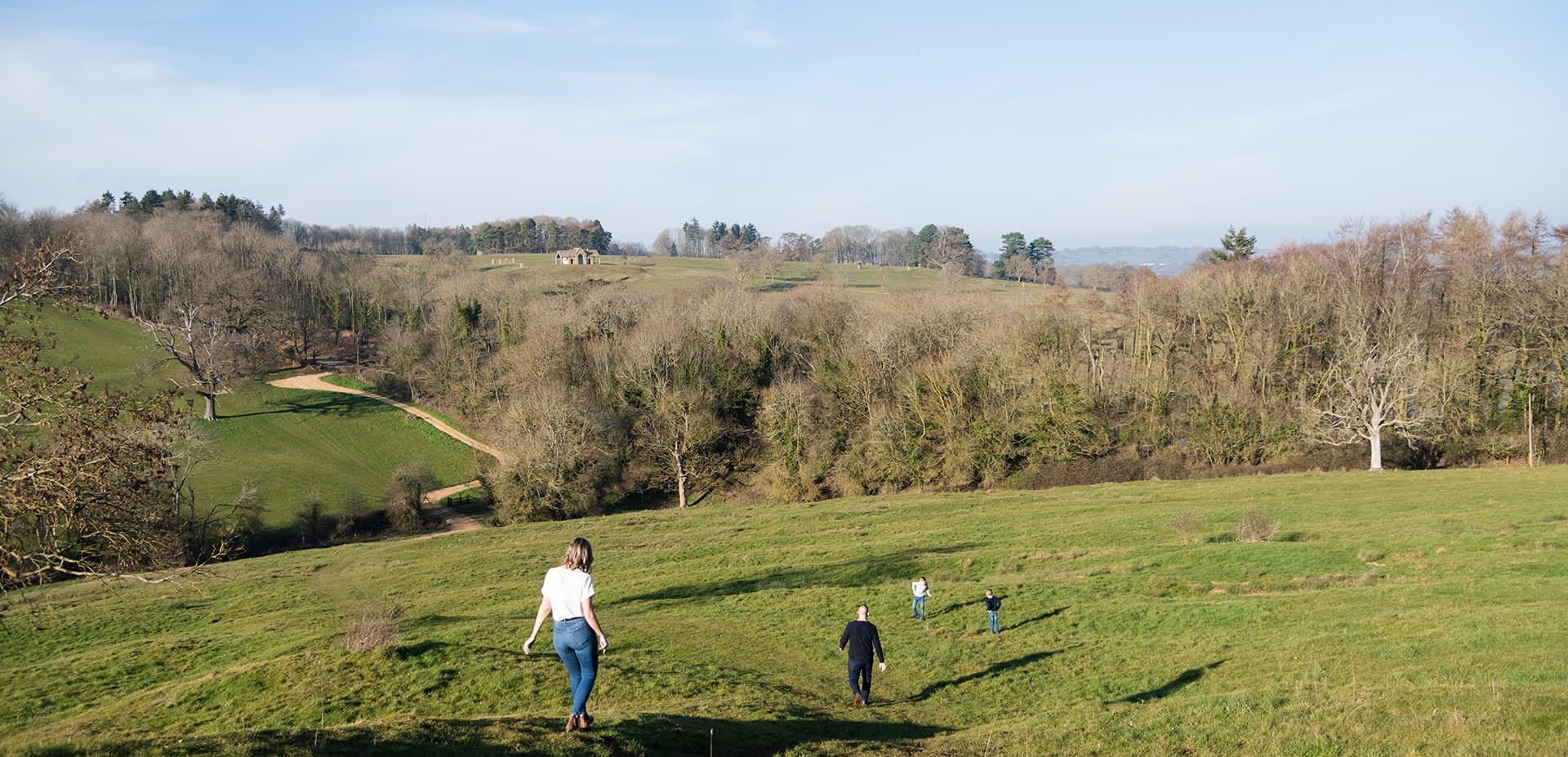 Family walking on a footpath down a hill near Chipping Campden with the two children ahead waiting